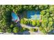 Aerial view of community featuring pool, tennis courts, parking and verdant surrounding landscape at 3102 Royal Troon, Woodstock, GA 30189