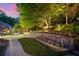Landscaped backyard with a stone retaining wall and colorful flowerbeds at 3102 Royal Troon, Woodstock, GA 30189