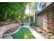 A stunning backyard featuring lush landscaping, stone walkways, and a charming outdoor fireplace at 3102 Royal Troon, Woodstock, GA 30189