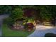 A brick retaining wall with flowers and landscape lighting adds beauty to the home's exterior at 3102 Royal Troon, Woodstock, GA 30189