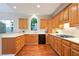 Galley kitchen featuring wood cabinets, modern appliances and hardwood floors at 3102 Royal Troon, Woodstock, GA 30189