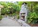 Backyard with a stone fireplace, lush landscaping, and a tranquil pond for relaxation at 3102 Royal Troon, Woodstock, GA 30189