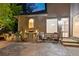 An outdoor kitchen, seating area and door to the interior sit on a brick paver patio at 3102 Royal Troon, Woodstock, GA 30189