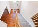 Carpeted staircase leading to foyer with hardwood flooring and bright entry door at 3102 Royal Troon, Woodstock, GA 30189