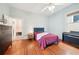 Bedroom featuring hardwood floors, electric piano and white ceiling fan near open door to bathroom at 621 Mcgruder Ne St, Atlanta, GA 30312