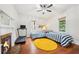 Bedroom with hardwood floors, decorative fireplace, two twin beds with yellow rug and ceiling fan at 621 Mcgruder Ne St, Atlanta, GA 30312