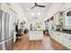 Open kitchen with stainless steel refrigerator, white cabinets, granite counters, an island and hardwood floors at 621 Mcgruder Ne St, Atlanta, GA 30312
