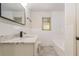 A well-lit bathroom features a tile floor, tile walls, a marble countertop and a large mirror at 201 E Simon Nw Ter, Atlanta, GA 30318