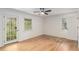 Bright bedroom featuring hardwood floors, a ceiling fan, and natural light from two windows and glass panel door at 201 E Simon Nw Ter, Atlanta, GA 30318