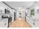 Modern white kitchen featuring stainless steel appliances, marble counters, and hardwood flooring at 201 E Simon Nw Ter, Atlanta, GA 30318