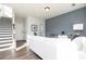 Bright living room with hardwood floors, gray accent wall, modern furniture, and stairs to the upper level at 357 Skylar Se Ct, Atlanta, GA 30315
