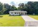 Charming one-story home with white exterior, a carport, manicured lawn, and lovely landscaping at 10 Casey Ln, Cartersville, GA 30121