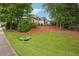 Back exterior of home featuring a sloped lawn and mature landscaping at 132 Eagles Club Dr, Stockbridge, GA 30281