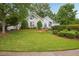 Charming white home featuring a well-manicured lawn and beautifully landscaped front yard at 132 Eagles Club Dr, Stockbridge, GA 30281