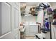 A well-lit laundry room boasts a washer and dryer, wire shelving, and cleaning supplies at 132 Eagles Club Dr, Stockbridge, GA 30281