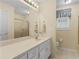 Neutral bathroom with a long countertop, bright vanity lighting, and a shower with gold trim at 219 Eagles Landing Way, Mcdonough, GA 30253