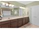 Well lit bathroom vanity featuring double sinks and dark wood cabinets at 219 Eagles Landing Way, Mcdonough, GA 30253