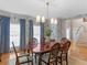 Elegant dining room featuring wallpaper, wood floors, and a modern chandelier above a mahogany table at 219 Eagles Landing Way, Mcdonough, GA 30253