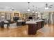 Open-concept kitchen and living room featuring a large island, stone fireplace, hardwood floors, and abundant natural light at 219 Eagles Landing Way, Mcdonough, GA 30253