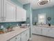 Bright laundry room with white cabinets, light countertop, and grey accent wall at 219 Eagles Landing Way, Mcdonough, GA 30253