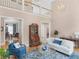 Bright, two-story living room features hardwood floors, modern decor, and an open floor plan with views of the dining room at 219 Eagles Landing Way, Mcdonough, GA 30253