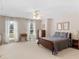 Spacious main bedroom featuring neutral walls, plush carpet, and a ceiling fan with a decorative light fixture at 219 Eagles Landing Way, Mcdonough, GA 30253