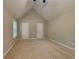 Spacious bedroom with neutral carpet, vaulted ceiling, and two white doors provides a bright, airy feel at 2312 Mahogany Glen Pl, Lawrenceville, GA 30043