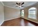 The bedroom features hardwood floors, a ceiling fan, and arched windows, offering ample natural light at 2312 Mahogany Glen Pl, Lawrenceville, GA 30043