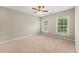 Bedroom featuring neutral carpet, a ceiling fan, and two windows allowing natural light to fill the room at 2312 Mahogany Glen Pl, Lawrenceville, GA 30043