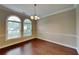 Inviting dining room with hardwood floors, elegant chandelier, and natural light from the arched windows at 2312 Mahogany Glen Pl, Lawrenceville, GA 30043