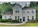 Charming two-story home boasts a well-maintained lawn and landscaped yard with a welcoming blue front door at 2312 Mahogany Glen Pl, Lawrenceville, GA 30043