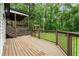 Spacious wood back deck with stairs, a hammock, and outdoor playground visible in lush, green backyard at 5006 Dekalb Way, Stone Mountain, GA 30087