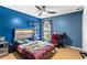 Blue bedroom features wood floor, ceiling fan, window, and desk area at 5006 Dekalb Way, Stone Mountain, GA 30087