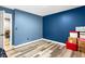 This bedroom features blue walls, wood floors, and boxes on the floor at 5006 Dekalb Way, Stone Mountain, GA 30087
