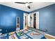 Blue bedroom with ceiling fan, closet and door leading to other spaces of home at 5006 Dekalb Way, Stone Mountain, GA 30087