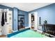 This bedroom features blue walls, wood floors, closets, shelving, and a bed at 5006 Dekalb Way, Stone Mountain, GA 30087