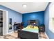 This bedroom features blue walls, wood floors, a closet, a desk, and a nice bed at 5006 Dekalb Way, Stone Mountain, GA 30087