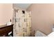 Cozy bathroom featuring a shower with decorative curtain and vanity storage at 8436 Cyprus Ridge Way, Douglasville, GA 30134