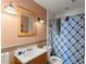Well-lit bathroom featuring a wooden vanity, soft lighting, and a blue-patterned shower curtain at 8436 Cyprus Ridge Way, Douglasville, GA 30134
