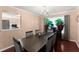 Elegant dining room with dark wood table, seating for six, and natural light from a large window at 8436 Cyprus Ridge Way, Douglasville, GA 30134