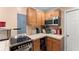 Compact kitchen with wood cabinets, laminate countertops, and modern appliances at 8436 Cyprus Ridge Way, Douglasville, GA 30134