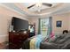Main bedroom featuring a tray ceiling, a large window and a decorative ceiling fan at 8436 Cyprus Ridge Way, Douglasville, GA 30134