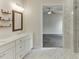 Well-lit bathroom with double sink vanity, decorative shelves, and seamless access to the en suite bedroom at 1023 Harvest Park Ln, Suwanee, GA 30024