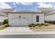 Two-car garage with white siding, dark accents and a small green space at 1023 Harvest Park Ln, Suwanee, GA 30024