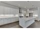 Modern kitchen features white cabinets, a large island, stainless steel appliances, and hardwood floors at 1023 Harvest Park Ln, Suwanee, GA 30024
