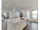 Island kitchen with hardwood floors, recessed lights, stainless appliances, and adjacent living space at 1023 Harvest Park Ln, Suwanee, GA 30024