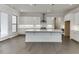 Modern kitchen with white cabinets, a large island, stainless steel appliances, and hardwood floors at 1023 Harvest Park Ln, Suwanee, GA 30024