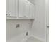 A clean, simple laundry room with white cabinets and tile flooring, ready for efficient chore management at 1023 Harvest Park Ln, Suwanee, GA 30024