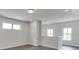 Open living area with hardwood floors, three windows, and neutral paint at 1023 Harvest Park Ln, Suwanee, GA 30024