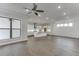 Open-concept living room with bright kitchen featuring recessed lighting, hardwood flooring, and expansive windows at 1023 Harvest Park Ln, Suwanee, GA 30024